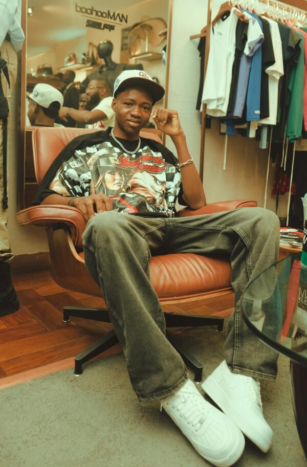 Youthful individual posing confidently in urban fashion attire within a stylish clothing store.